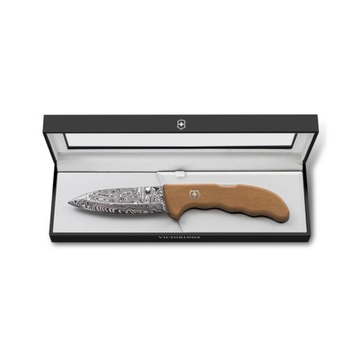 Geöffnetes Victorinox Evoke Wood Damastmesser 2026 in der Seitenansicht, fokussiert auf das Gysinge-Muster der Damastklinge und die Maserung der Platanenholzschale.