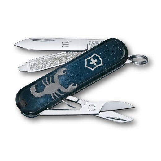 Geöffnetes Victorinox Classic SD 58 mm Taschenmesser aus der Zodiac Signs Serie mit dem Motiv des Sternzeichens Skorpion. Sichtbar sind die ausgeklappte Klinge mit Sternzeichensymbol, Schere und Nagelfeile vor dunkelblauem Sternenhimmel-Design.