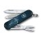 Geöffnetes Victorinox Classic SD 58 mm Taschenmesser aus der Zodiac Signs Serie mit dem Motiv des Sternzeichens Schütze. Sichtbar sind die ausgeklappte Klinge mit Sternzeichensymbol, Schere und Nagelfeile vor dunkelblauem Sternenhimmel-Design.
