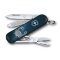 Geöffnetes Victorinox Classic SD 58 mm Taschenmesser aus der Zodiac Signs Serie mit dem Motiv des Sternzeichens Krebs. Sichtbar sind die ausgeklappte Klinge mit Sternzeichensymbol, Schere und Nagelfeile vor dunkelblauem Sternenhimmel-Design.
